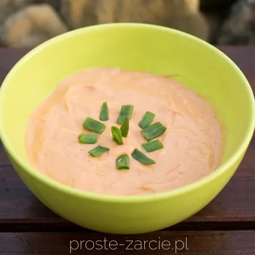 Sos farmera ze szczypiorkiem w małej miseczce, przygotowany jako dodatek do karkówki z grilla.