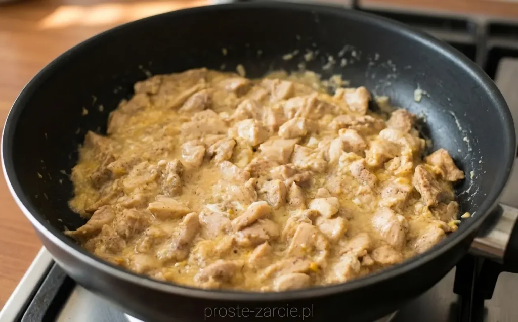 Smażony ryż z kawałkami kurczaka i jajkiem, mocno pokryty ciemnym sosem ostrygowym, podany obok pokrojonych świeżych pomidorów.