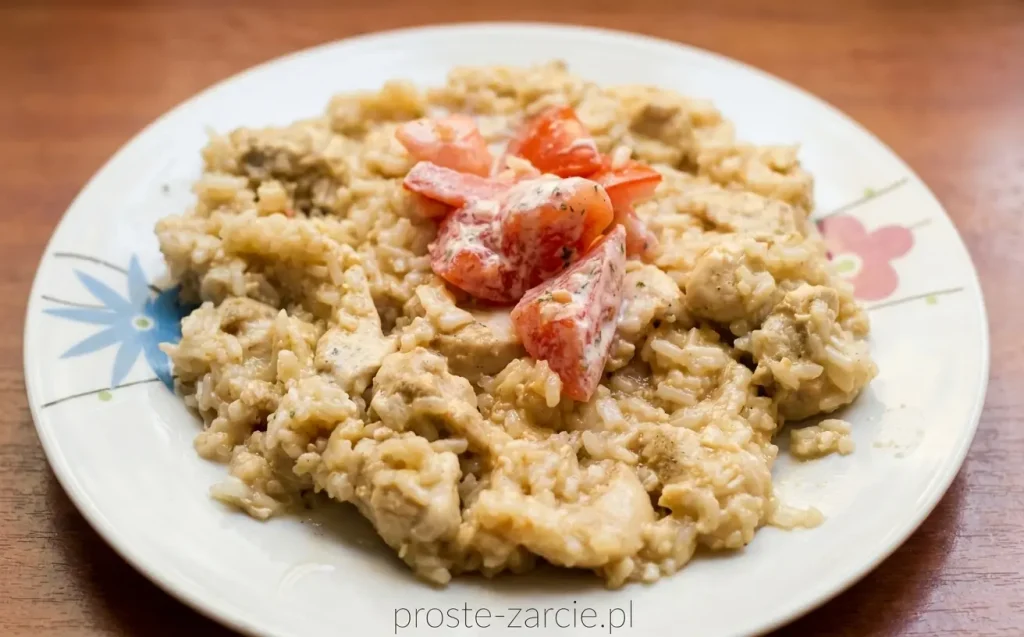 Smażony ryż z kawałkami kurczaka i jajkiem, mocno pokryty ciemnym sosem ostrygowym, podany obok pokrojonych świeżych pomidorów.