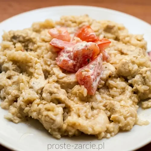 Smażony ryż z kawałkami kurczaka i jajkiem, mocno pokryty ciemnym sosem ostrygowym, podany obok pokrojonych świeżych pomidorów.
