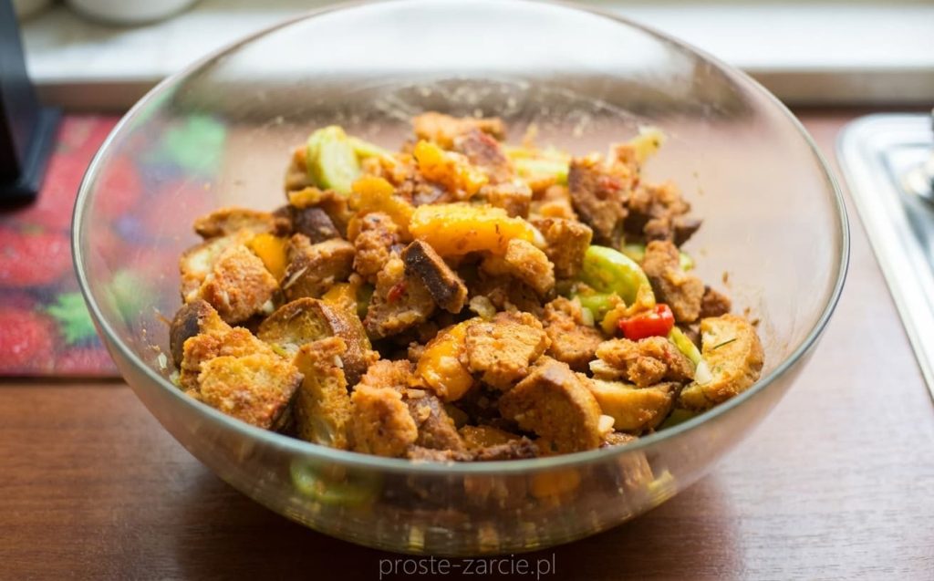 Włoska sałatka panzanella w misie – kawałki pieczonego chleba wymieszane z czerwonymi pomidorami, ogórkiem i świeżą bazylią.