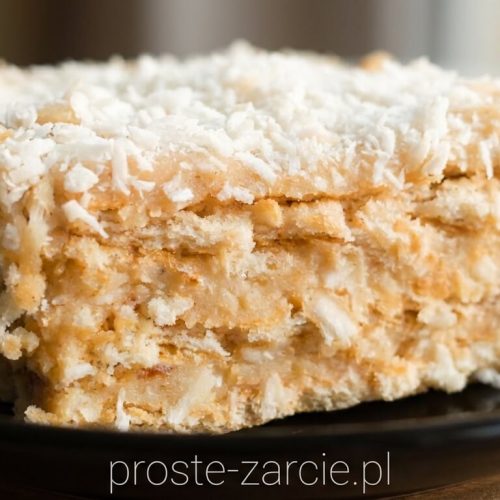 Ciasto kokosowe Rafaello na krakersach posypane wiórkami kokosowymi, biały kremowy deser bez pieczenia, proste żarcie