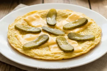Rumiany omlet z roztopionym serem i cebulką podawany z majonezem i ogórkiem kiszonym, pożywne śniadanie z jajek, proste żarcie