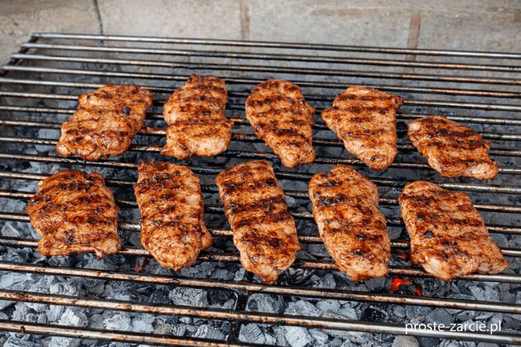 Soczysta grillowana szynka przypieczona na ruszcie z widocznymi śladami grilla i aromatycznym dymem