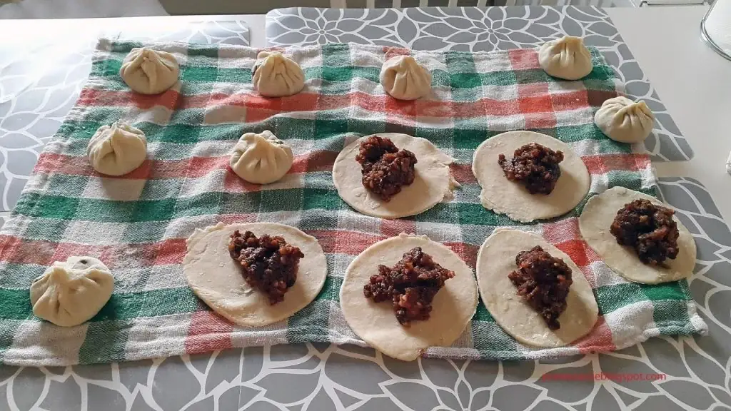 Parujące pierożki wonton w bambusowym koszyczku do gotowania na parze, podane z sosem sojowym.