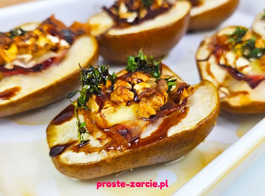Pieczone połówki gruszek z roztopionym serem camembert, szynką parmeńską, orzechami i gałązką tymianku.