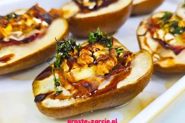 Pieczone połówki gruszek z roztopionym serem camembert, szynką parmeńską, orzechami i gałązką tymianku.