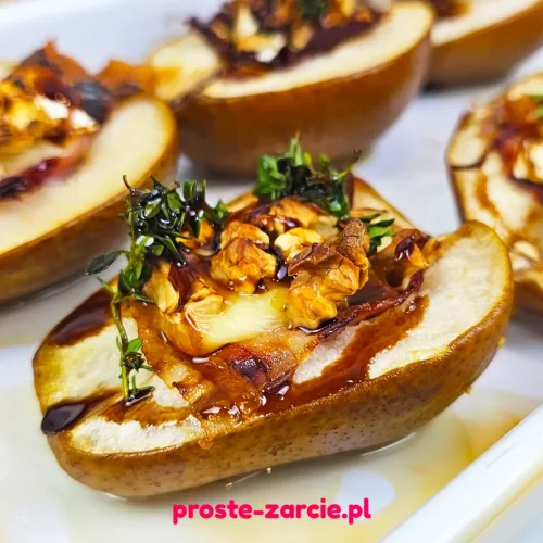 Pieczone połówki gruszek z roztopionym serem camembert, szynką parmeńską, orzechami i gałązką tymianku.